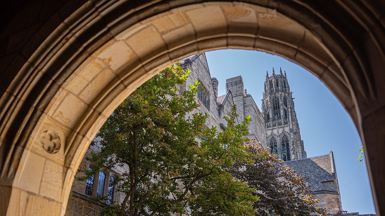 View of Harkness Tower through an archway on campus