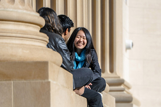 Students sitting together by pillars outside of the Schwarzman Center