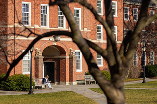 Student sitting on bench outside of Silliman College