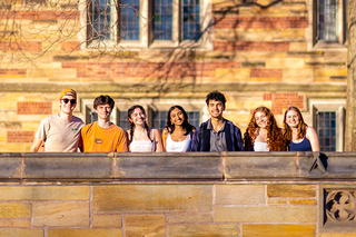 Group of students standing side by side posing for a photo on campus