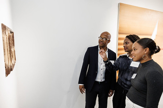 Group of attendees looking at art on a wall during the 2024 PLC Fall Gathering